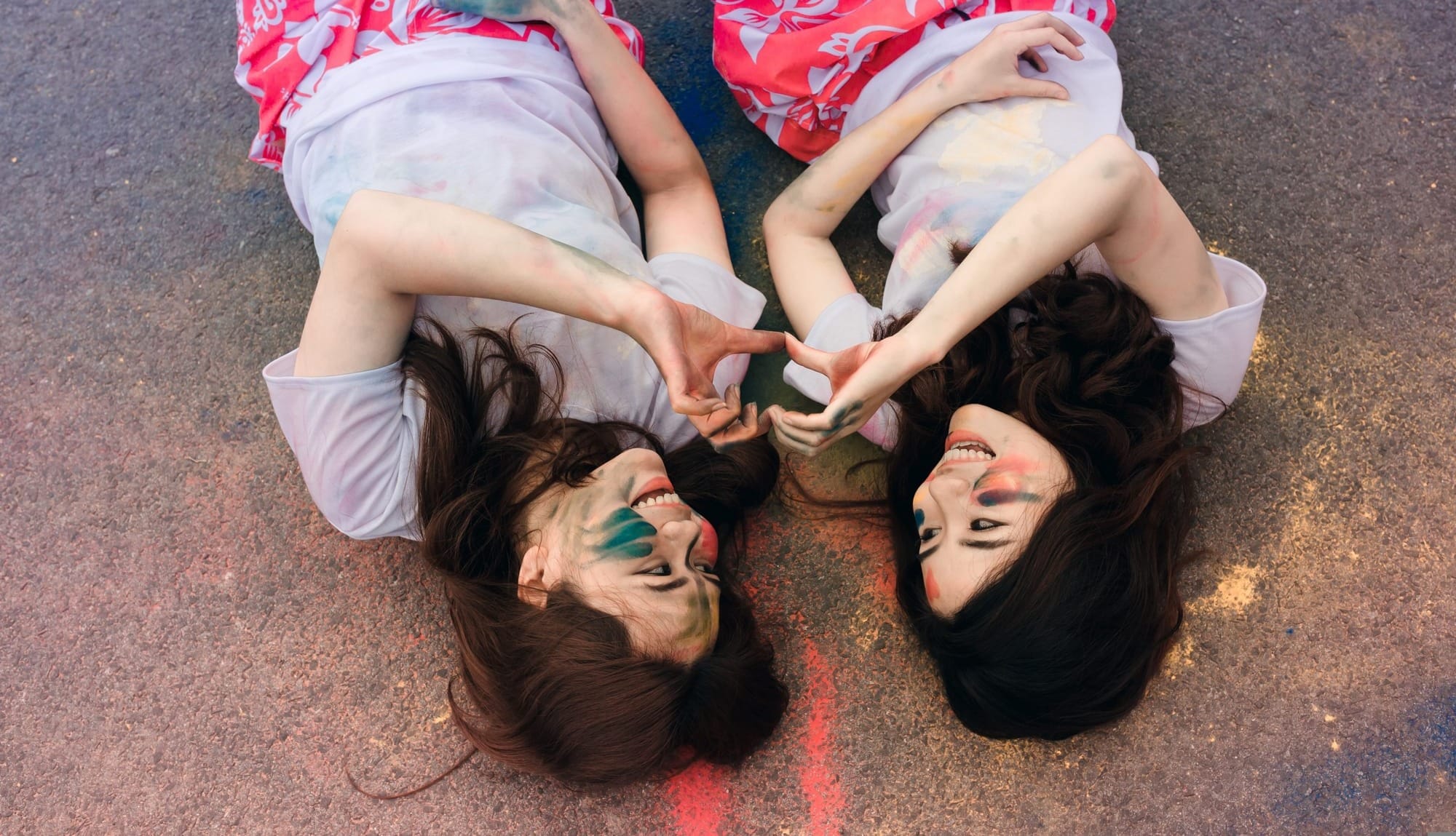 painted face girls smiling on asphalt